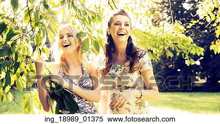 Stock Photography - Portrait of the two laughing girlfriends. Fotosearch