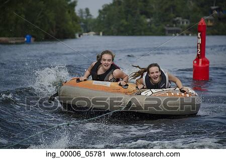 Portrait of two girls lying on an inflatable raft floating in a lake, Lake Of The Woods, Ontario, Canada View Large Photo Image Stock Image - Portrait of two girls lying on an inflatable raft floating in a lake, Lake Of The Woods, Ontario, Canada. Fotosearch