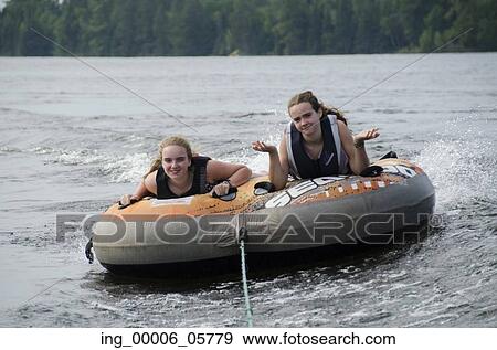 Portrait of two girls lying on an inflatable raft floating in a lake, Lake Of The Woods, Ontario, Canada View Large Photo Image Stock Photo - Portrait of two girls lying on an inflatable raft floating in a lake, Lake Of The Woods, Ontario, Canada. Fotosearch