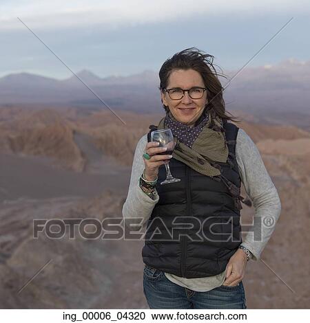 Portrait of woman holding a wine glass in desert, San Pedro de Atacama, El Loa Province, Antofagasta Region, Chile View Large Photo Image Stock Image - Portrait of woman holding a wine glass in desert, San Pedro de Atacama, El Loa Province, Antofagasta Region, Chile. Fotosearch