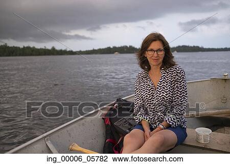 Portrait of woman sitting on a boat in a lake, Lake of the Woods, Ontario, Canada View Large Photo Image Stock Image - Portrait of woman sitting on a boat in a lake, Lake of the Woods, Ontario, Canada. Fotosearch