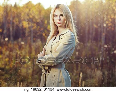 Picture - Portrait of young beautiful woman in autumn cloak. Fashion photo. Blonde girl. Perfect make-up. Fotosearch