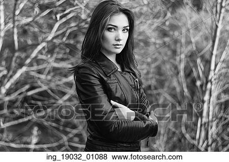 Stock Photo - Portrait of young beautiful woman in leather jacket. Fashion photo. Black and white. Fotosearch