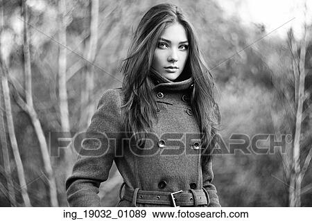Stock Photo - Portrait of young beautiful woman in autumn coat. Fashion photo. Black and white. Fotosearch