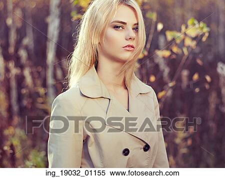 Stock Photography - Portrait of young beautiful woman in autumn cloak. Fashion photo. Blonde girl. Perfect make-up. Fotosearch