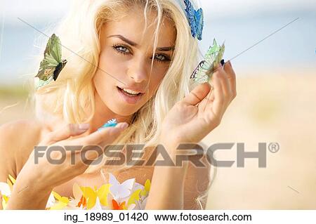 Stock Image - Pretty blond lady with a few colorful butterflies. Fotosearch