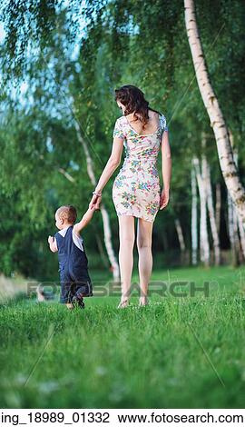 Stock Image - Pretty mother on the walk with baby. Fotosearch
