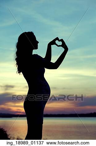 Stock Photo - Prgenant mother making the heart sign. Fotosearch
