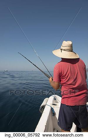 Rear view of a man fishing on boat in sea, Ixtapa, Zihuatanejo, Guerrero, Mexico View Large Photo Image Stock Image - Rear view of a man fishing on boat in sea, Ixtapa, Zihuatanejo, Guerrero, Mexico. Fotosearch