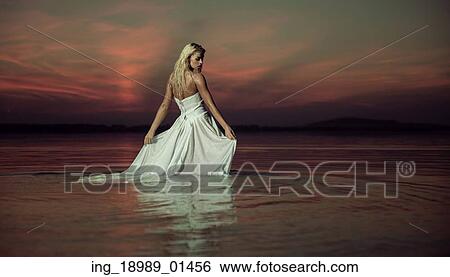 Stock Photograph - Sensual lady dancing in the lake. Fotosearch