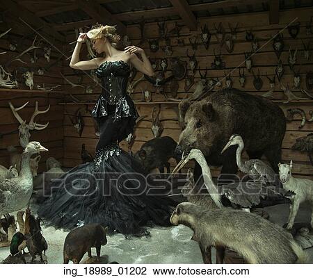 Stock Image - Sensual lady in a locked room full of wild animals. Fotosearch