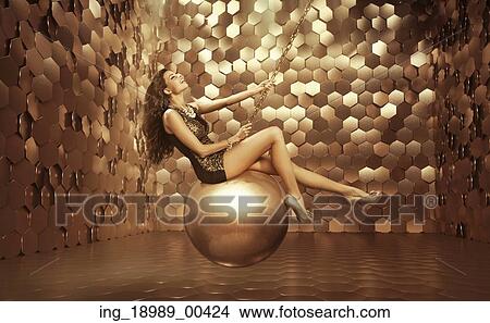 Picture - Sexy woman on the big golden ball. Fotosearch