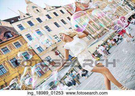 Stock Image - Shapely blonde catching the soap bubbles. Fotosearch