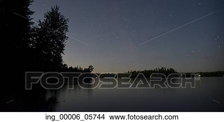 Picture - Silhouette of trees at lakeside, Lake of the Woods, Ontario, Canada. Fotosearch