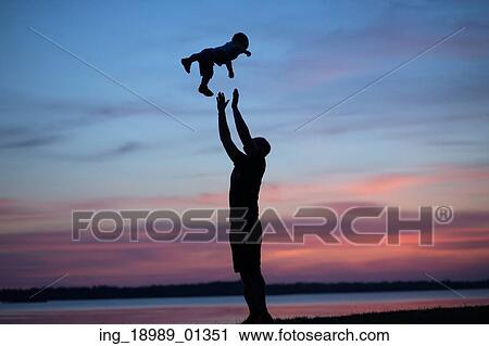Stock Image - Silhouettes of dad tossing his child. Fotosearch