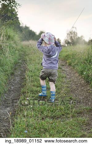 Stock Image - Small kid walking on the forest path. Fotosearch
