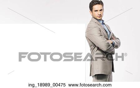 Stock Photography - Smart man wearing suit next to the empty board. Fotosearch