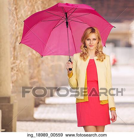 Stock Photo - Smart woman waling with the umbrella. Fotosearch