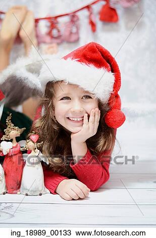 Smiling and cute girl in a Santa hat View Large Photo Image Stock Image - Smiling and cute girl in a Santa hat. Fotosearch