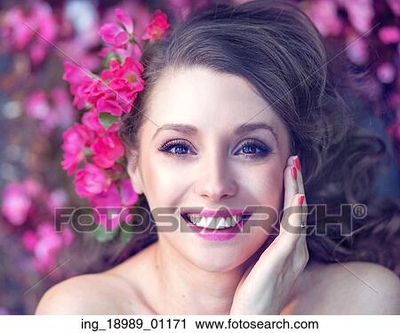 Smiling brunette among the pink flowers View Large Photo Image Stock Image - Smiling brunette among the pink flowers. Fotosearch