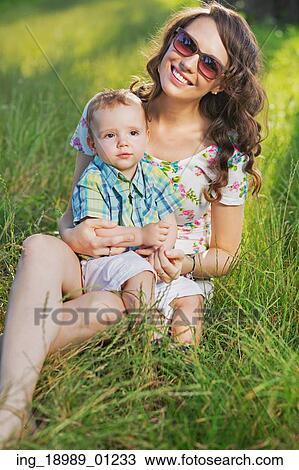 Stock Image - Smiling pretty mother hugging lovely child. Fotosearch