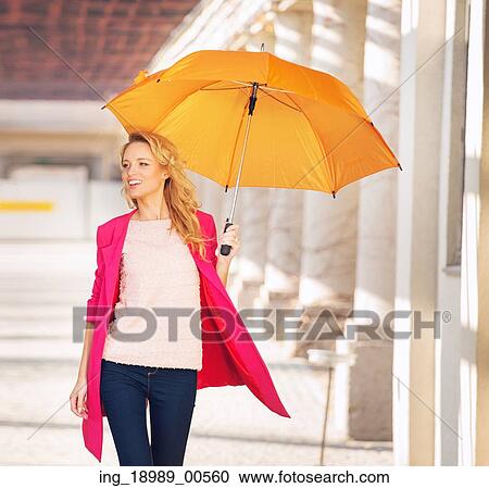 Stock Image - Smiling smart lady with the umbrella. Fotosearch