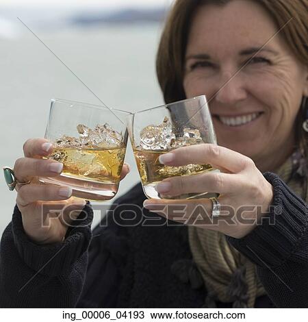 Smiling woman holding glasses of whisky, Lake Argentino, Santa Cruz Province, Patagonia, Argentina View Large Photo Image Stock Image - Smiling woman holding glasses of whisky, Lake Argentino, Santa Cruz Province, Patagonia, Argentina. Fotosearch