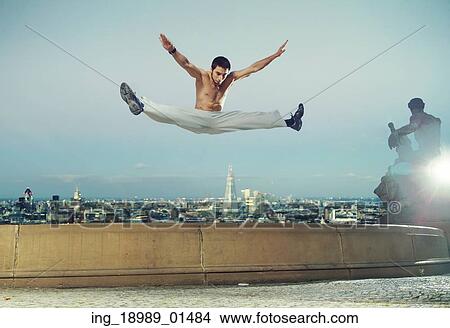 Picture - Strong muscular man doing the splits. Fotosearch