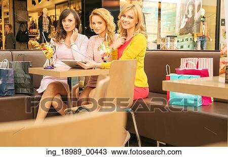 Stock Image - Three attractive ladies in the shopping mall. Fotosearch