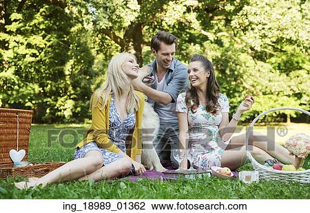 Stock Image - Three friends during the summer picnic. Fotosearch