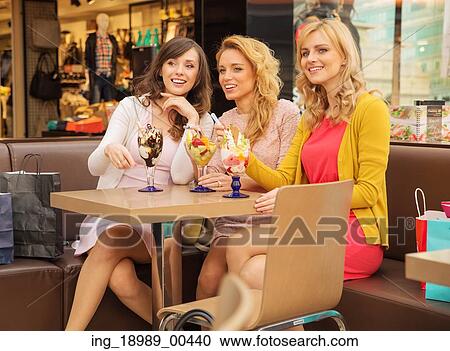Stock Image - Three smiling girlfriends having the short break time. Fotosearch