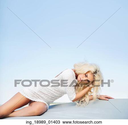 Stock Image - Tired blond woman lying on the ground. Fotosearch