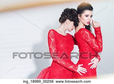 Stock Photo - Two alluring ladies wearing great dresses. Fotosearch