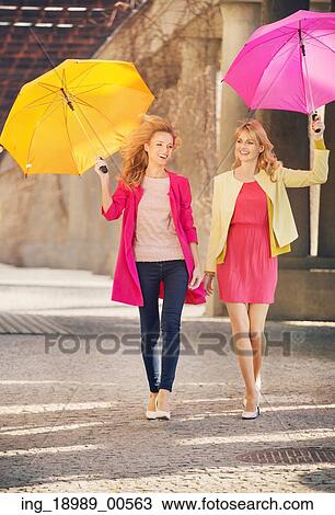 Two cheerful girlfriends walking during windy day View Large Photo Image Stock Image - Two cheerful girlfriends walking during windy day. Fotosearch
