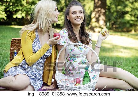 Two marvelous girlfriends sitting on the blanket View Large Photo Image Stock Photo - Two marvelous girlfriends sitting on the blanket. Fotosearch