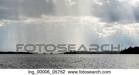 Stock Image - View of distant rain falling at Lake of the Woods, Ontario, Canada. Fotosearch