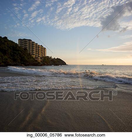 View of surf on the beach at sunsest with apartment buildings in background, Ixtapa, Zihuatanejo, Guerrero, Mexico View Large Photo Image Stock Photograph - View of surf on the beach at sunsest with apartment buildings in background, Ixtapa, Zihuatanejo, Guerrero, Mexico. Fotosearch