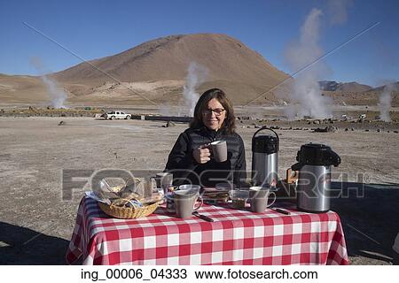 Stock Image - Woman having breakfast at El Tatio, Calama, San Pedro de Atacama, El Loa Province, Antofagasta Region, Chile. Fotosearch
