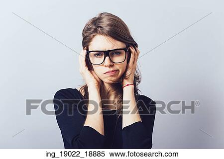 Woman in glasses, adjusts his glasses or hair on a grey background View Large Photo Image Stock Photography - Woman in glasses, adjusts his glasses or hair on a grey background. Fotosearch