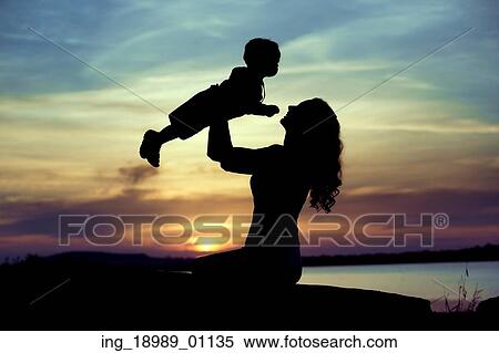 Stock Photography - Woman lifting up her little child. Fotosearch
