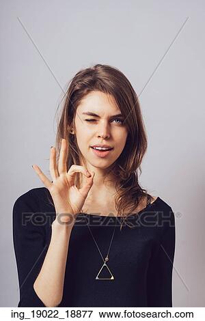 Woman shows okay on a gray background. View Large Photo Image Stock Photo - Woman shows okay on a gray background.. Fotosearch