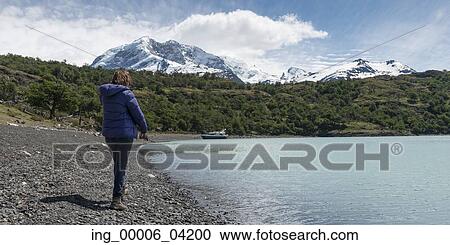 Stock Image - Woman standing at Lake Argentino, Santa Cruz Province, Patagonia, Argentina. Fotosearch