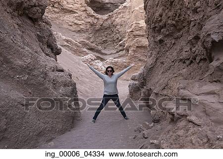 Woman standing with her arms outstretched, Valle de la Luna, San Pedro de Atacama, El Loa Province, Antofagasta Region, Chile View Large Photo Image Picture - Woman standing with her arms outstretched, Valle de la Luna, San Pedro de Atacama, El Loa Province, Antofagasta Region, Chile. Fotosearch