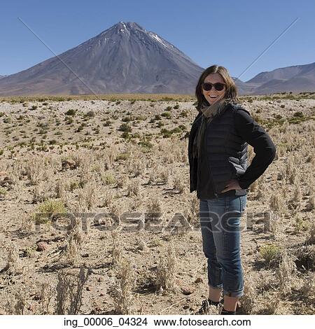 Woman standing with Licancabur volcano in background, Salar De Atacama, San Pedro de Atacama, El Loa Province, Antofagasta Region, Chile View Large Photo Image Picture - Woman standing with Licancabur volcano in background, Salar De Atacama, San Pedro de Atacama, El Loa Province, Antofagasta Region, Chile. Fotosearch