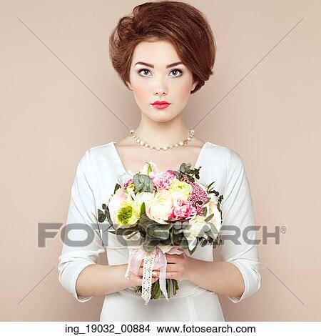 Picture - Woman with bouquet of flowers in her hands. Flowers. Spring. Bride. March 8. Fashion photo. Fotosearch