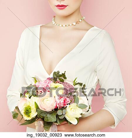 Stock Image - Woman with bouquet of flowers in her hands. Flowers. Spring. Bride. March 8. Fashion photo. Fotosearch