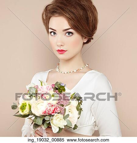 Stock Photography - Woman with bouquet of flowers in her hands. Flowers. Spring. Bride. March 8. Fashion photo. Fotosearch