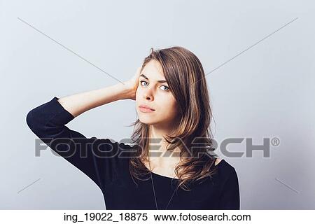 Stock Photography - Woman with hand on head, straightens the hair. Fotosearch