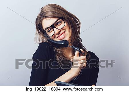 Woman with office or home phone. On a gray background. View Large Photo Image Picture - Woman with office or home phone. On a gray background.. Fotosearch