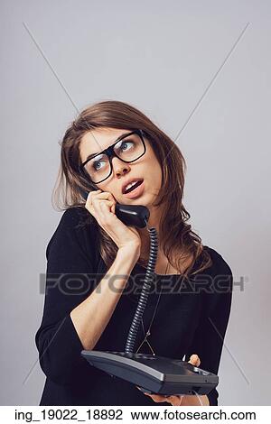 Woman with office or home phone. On a gray background. View Large Photo Image Stock Image - Woman with office or home phone. On a gray background.. Fotosearch